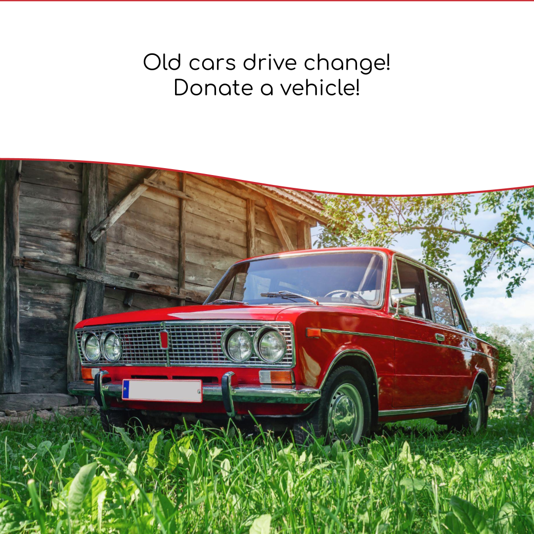 Cherry red antique car parked on green grass beside an old shed. Donate a Car Canada blog image has a banner across the top that reads, "old cars drive change! Donate a vehicle!""